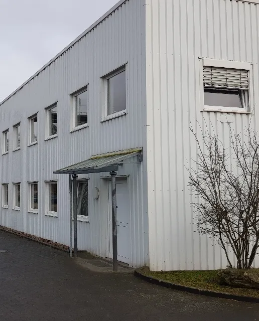 Weißer Büro- und Verwaltungstrakt mit Vordach