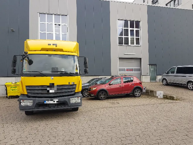 Gewerbehof mit Lkw vor einer grauen Halle